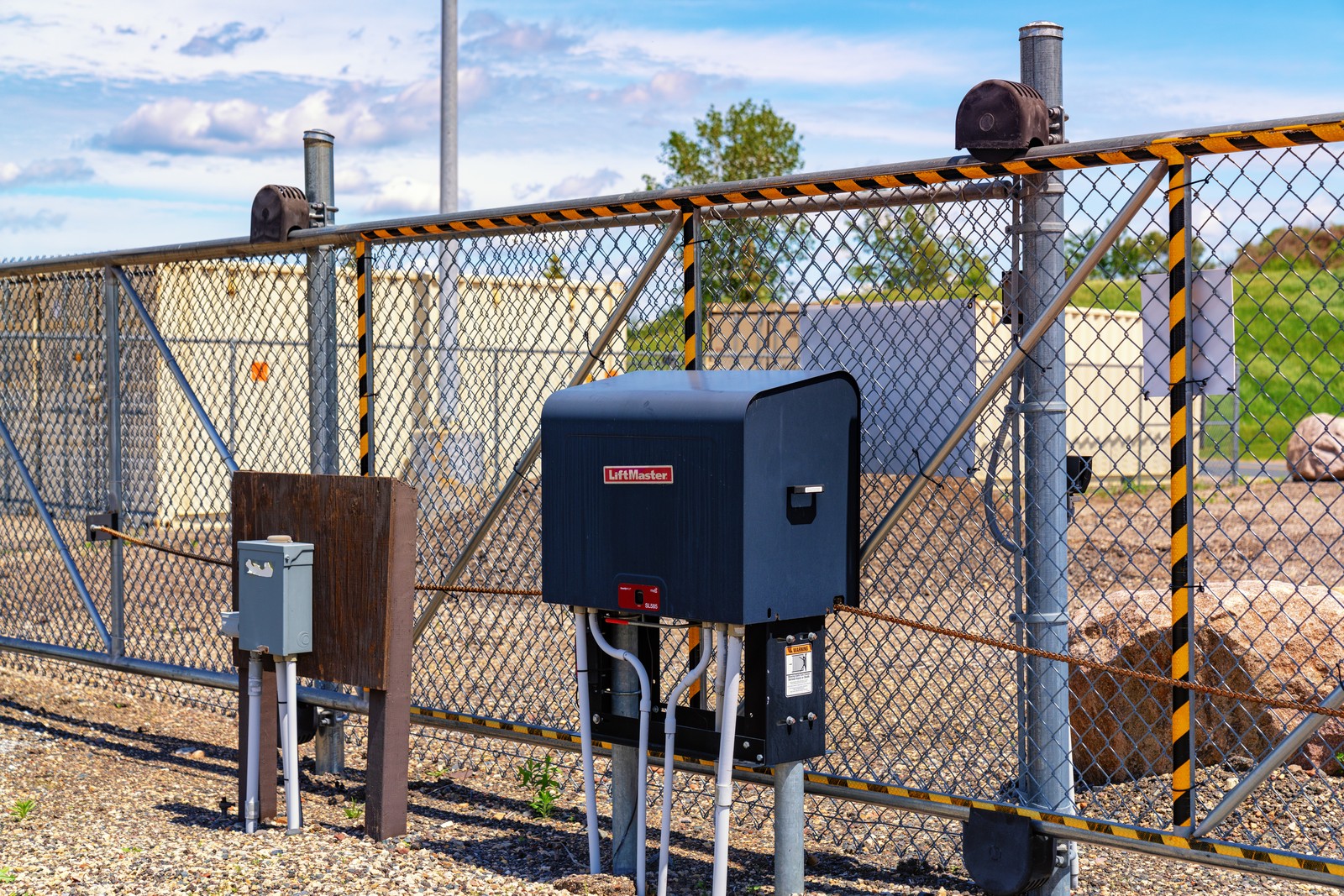 LiftMaster SL585 motorized slide-gate operator beside a chain-link gate