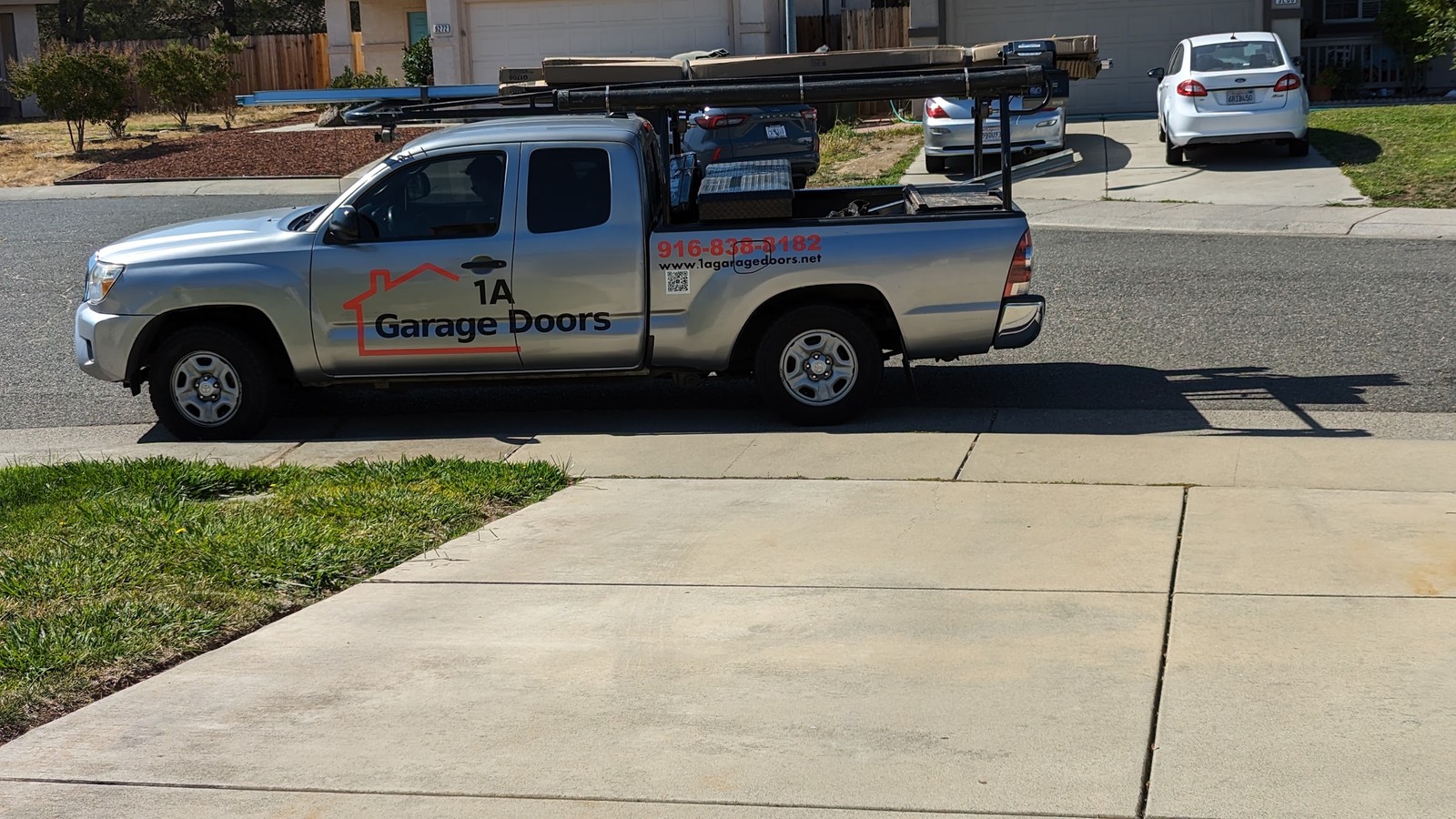 1A Garage Doors service truck outside a residential garage
